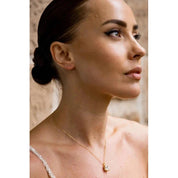 Gold-plated Elaine cushion-cut cubic zirconia pendant on a delicate chain worn by a woman for an elegant, sparkling look.